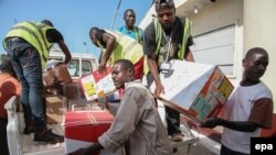 Des travailleurs déchargent un avion à l'aéroport Spriggs Payne à Monrovia, au Libéria, 2 avril 2014.