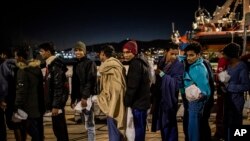 Bangladeshis rescued off the Libyan coast line up to be registered by police at the port of Messina after disembarking from an Open Arms rescue vessel, in Sicily, Italy, Jan. 15, 2020. A second Open Arms vessel was in search of a port Feb. 1.