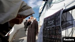 Ultra-Orthodox Jewish man reacts in front of a newspaper's front page with the Hebrew words "National Mourning", at the site where dozens were crushed to death in a stampede at a religious festival, May 2, 2021.