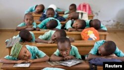 FILE - Boys rest their heads on their desks during a language class in Cameroon's capital, Yaounde. Strikes by teachers and lawyers to push for more use of English have turned violent, and schools have closed.