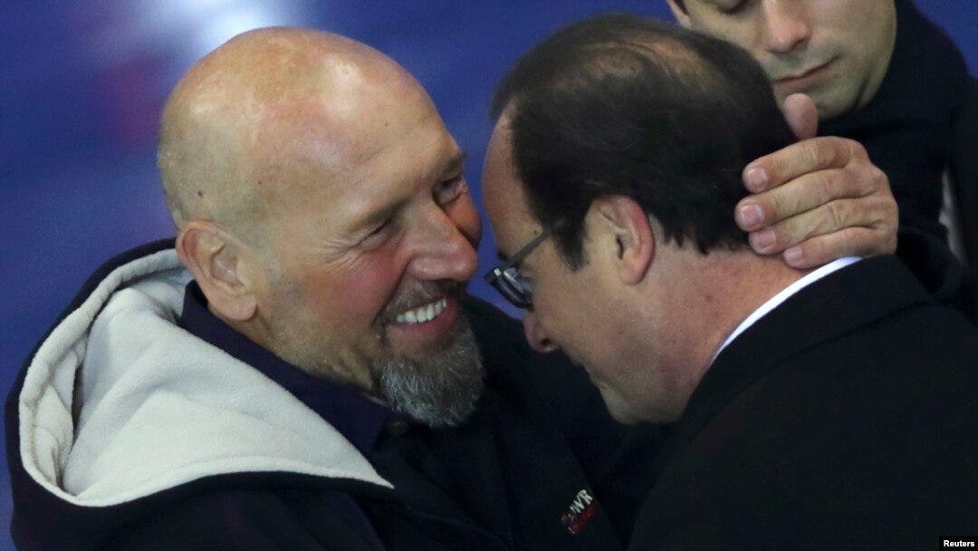 Presiden Perancis Francois Hollande (kanan) dan bekas tawanan al-Qaida Africa Utara yang baru saja dibebaskan, Serge Lazarevic, saling berpelukan seusai menyampaikan sambutan di bandara militer Villacoublay dekat Paris (10/12).