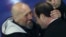 French President Francois Hollande (R) and former hostage Serge Lazarevic hug each other after delivering speeches at the Villacoublay military airport, near Paris, Dec. 10, 2014.