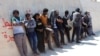 FILE - Migrants are seen after they were picked up by a coast guard patrol after a boat accident off the Libyan coast in Qarabulli town, east of the capital Tripoli, Libya, June 2, 2019.