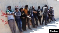 FILE - Migrants are seen after they were picked up by a coast guard patrol after a boat accident off the Libyan coast in Qarabulli town, east of the capital Tripoli, Libya, June 2, 2019.