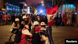 Manifestantes sostienen escudos improvisados durante una protesta contra el gobierno en Lima, Perú, el 4 de febrero de 2023. 