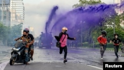 Người biểu tình bỏ chạy khi cảnh sát phun vòi rồng ở Bangkok, 29/8/2021.
