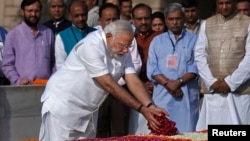 O primeiro-ministro recém eleito, Narendra Modi, deposita pétalas de rosa no memorial de Mahatma Gandhi em Rajghat, após a cerimónia de juramento de posse em Nova Deli, Índia, Maio 26, 2014. 