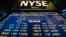 The New York Stock Exchange logo stands above a board displaying stock prices shortly after the beginning of trading, July 30, 2013. 