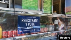 A voter registration sign is seen on a taco truck, as part of the U.S. Hispanic Chamber of Commerce's "Guac the Vote" campaign, in Houston, Texas, Sept. 29, 2016. 