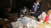 FILE: Zimbabwean election officials count ballot papers after the close of voting on a referendum in Harare, March 16, 2013.