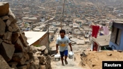 Archivo - Paola Grana colecta agua de un contenedor en el pueblo de Pamplona Alta en San Juan de Miraflores, en el distrito de LIma, el 10 de marzo de 2015.