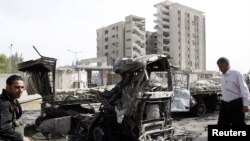 ເຈົ້າໜ້າທີ່ຮັກສາຄວາມປອດໄພຢືນຢູ່ໃກ້ໆກັບບ່ອນລະເບີດແຕກຂຶ້ນໃນກຸງ ດາມັສກັສ.
ວັນທີ 10 ພຶດສະພາ 2012. 