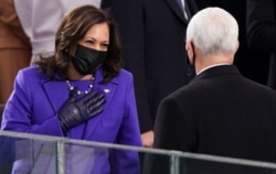Vice President-elect Kamala Harris gestures towards U.S. Vice President Mike Pence ahead of the inauguration of Joe Biden as the 46th President of the United States .