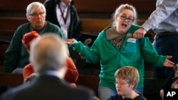 Heaven Chamberlain, of Des Moines, Iowa, right, asks Rep. David Young, R-Iowa, a question during a town hall meeting, April 12, 2017, in Des Moines, Iowa