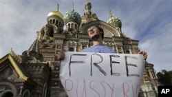 Aktivis Rusia pendukung kelompok musik Pussy Riot membawa tulisan 'Bebaskan Pussy Riot' di depan gereja katedral di St.Petersburg, Rusia (17/8). 