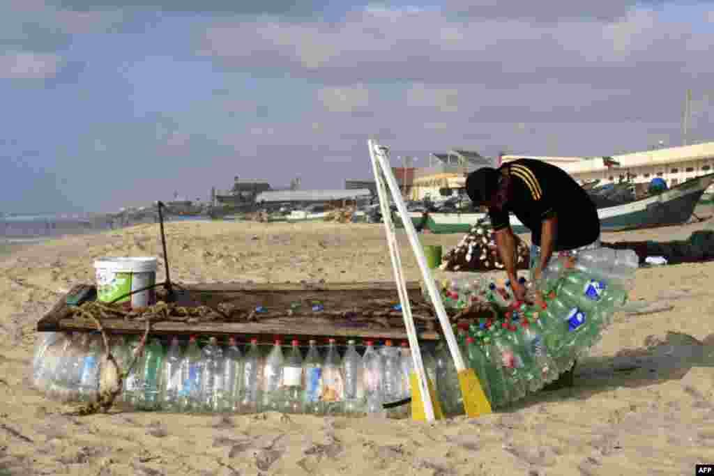 팔레스타인 라파에서 남성이 700개의 빈 플라스틱 병으로 만든 어선을 고치고 있다.