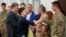 Newly-released Ukrainian pilot Nadiya Savchenko, center left, is congratulated by fellow servicemen in the Presidential Office in Kyiv, Ukraine, May 25, 2016. Ukrainian President Petro Poroshenko is second left. Russia released Savchenko as part of a swap
