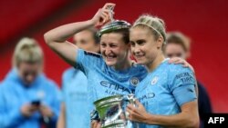 L'attaquante anglaise de Manchester City Ellen White (C) et la défenseure de Manchester City Steph Houghton (R) après avoir remporté la finale de la coupe anglaise. Catherine Ivill / POOL / AFP) /