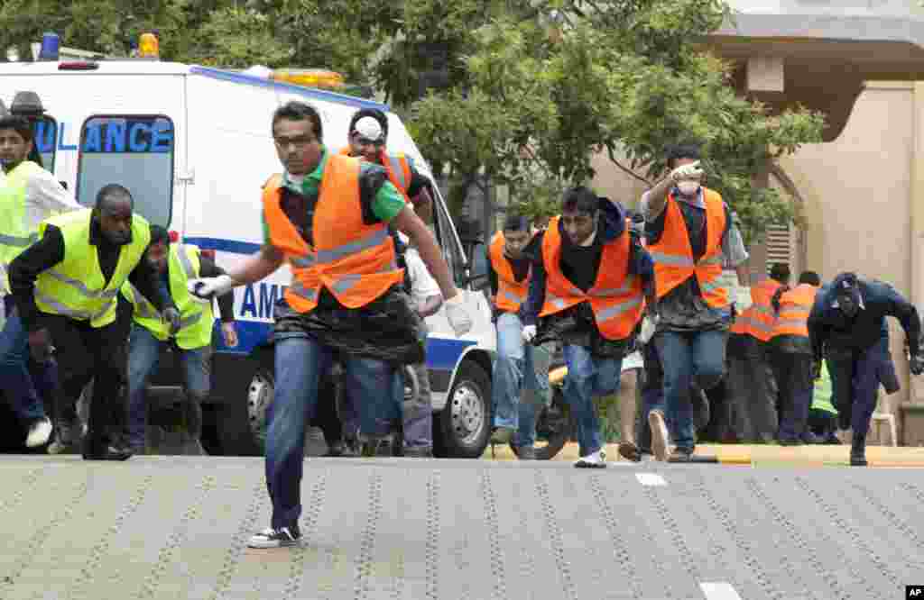 Paramedics run outside the Westgate Mall in Nairobi after heavy shooting, Sept. 23, 2013.