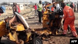 Le personnel de l'agence nationale de gestion des urgences (NEMA) déplace la carcasse d'une voiture près de la frontière somalienne, au Nigeria, le 29 octobre 2016.