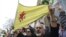 FILE - A man holds a flag of the YPG, a Syria-based Kurdish militant group, during a protest against Turkish President Recep Tayyip Erdogan in front of the Brookings Institution in Washington, where Erdogan was speaking, March 31, 2016.