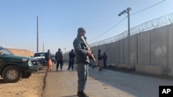 Security stand guard near the site of attack near the Bagram Air Base in Parwan province of Kabul, Afghanistan, Wednesday, Dec. 11, 2019.
