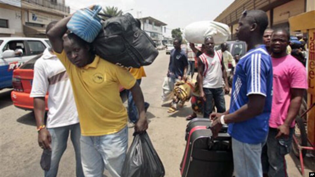 People walk with their belongings towards a railway station as they leave Abidjan, Ivory Coast.(file photo)