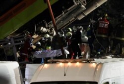 Personal de rescate recupera cadáveres de la escena de un accidente en el que cayeron vagones del Metro luego de que un tramo de la Línea 12 colapsara en la Ciudad de México, el martes 4 de mayo de 2021.