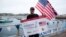 Bryce Carlson, a high school biology teacher, rowing coach and endurance athlete from Cincinnati, Ohio, U.S.A., holds a banner, after completing a solo, unassisted row across the North Atlantic Ocean, upon his arrival at St. Mary's, on the Isles of Scilly, Britain, Aug. 4, 2018.