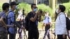 FILE - In this photo taken from video, Garry Pang Moon-yuen, center, is seen outside the West Kowloon Court, in Hong Kong, Nov. 29, 2021. 