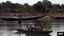 Une famille malienne est transportée sur un bateau sur le fleuve Niger à Port de Korioume, près de Tombouctou, le 9 mars 2016.