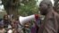 FILE - Ibrahim Abaka, the president of an internally displaced persons camp, uses a megaphone to organize the distribution of food aid in Bambari, Central African Republic, January 2017.