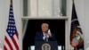 Presiden Donald Trump membuka maskernya untuk berpidato dari Blue Room Balcony di Gedung Putih di hadapan para pendukungnya, 10 Oktober 2020 di Washington. (Foto: Alex Brandon/AP)