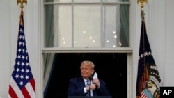 President Donald Trump removes his face mask to speak from the Blue Room Balcony of the White House to a crowd of supporters, Saturday, Oct. 10, 2020, in Washington. (AP Photo/Alex Brandon)