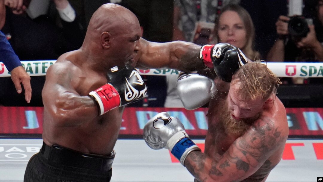 En esta instantánea Mike Tyson golpea a Jake Paul, durante su pelea de boxeo de peso pesado, el viernes 15 de noviembre de 2024, en Arlington, Texas. (Foto AP/Julio Cortez).