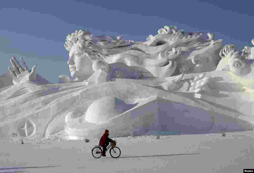 哈尔滨国际冰雪节的雪雕，有人骑车路过（2014年1月4日）