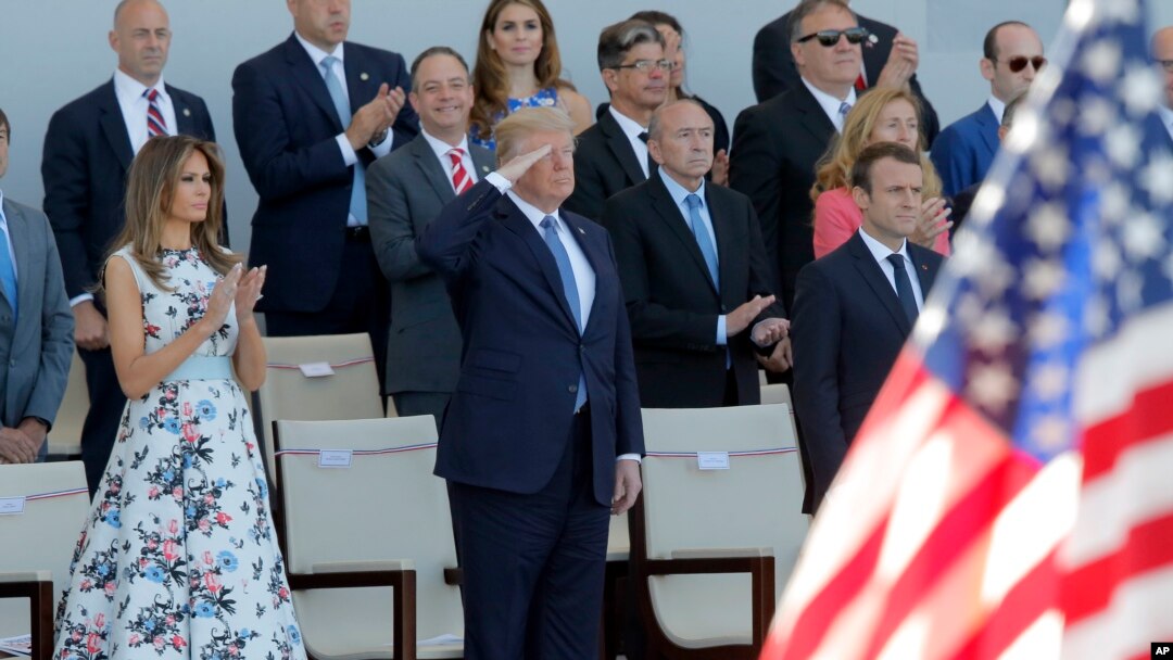 Presiden Perancis Emmanuel Macron (kanan), Presiden AS Donald Trump, dan Ibu Negara AS Melania Trump menyaksikan parade militer Hari Bastille di Champs Elysees, Paris, 14 Juli 2018.
