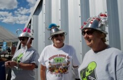From left, sisters Kathy Richey, Gerry Garcia and Sandy Haney wait in line for the gift shop at the Storm Area 51 Basecamp event, Sept. 20, 2019, in Hiko, Nev. The event was inspired by the "Storm Area 51" internet hoax.