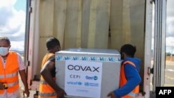 Trabajadores cargan cajas de vacunas COVID-19 de Oxford / AstraZeneca, parte del programa Covax, en un camión después de llegar en avión al Aeropuerto Internacional Ivato en Antananarivo, Madagascar, el 8 de mayo de 2021.