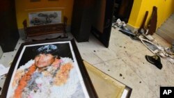 A broken portrait of Bolivia's former President Evo Morales is on the floor of his private home in Cochabamba, Bolivia, after hooded opponents broke into the residence Nov. 10, 2019. Morales resigned Sunday. 