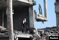 A Palestinian pistillate   stands wrong  a destroyed gathering  successful  Nuseirat, cardinal  Gaza Strip, aft  Israeli forces withdrew from parts of Nuseirat aft  a crushed  operations, Nov. 29, 2024.