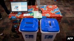 FILE — A new voting machine to be used during the Democratic Republic of the Congo's elections sits on a table beside two ballot boxes in Kinshasa, February 21, 2018.