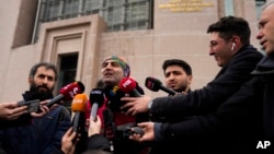 Mesut Ceki, center, a courier rights association member and colleague of Turkish motorcycle courier Yunus Emre Gocer, talks to journalist outside the Justice court in Istanbul, Turkey, Tuesday, Jan. 16, 2024.