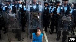 2019年6月12日，香港立法会外，一名抗议者坐在防暴警察面前。
