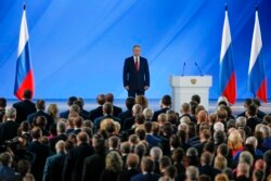 Russian President Vladimir Putin and officials listen to the national anthem after Putin's address to the Federal Assembly at the Manezh exhibition hall in downtown Moscow, Jan. 15, 2020.