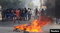 Residents stand next to a barricade on fire as they call for a strike during a protest against unfinished public works in Colon, Panama, March 13, 2018. 