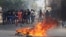 Residents stand next to a barricade on fire as they call for a strike during a protest against unfinished public works in Colon, Panama, March 13, 2018. 