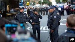  Officers watch over the scene outside the Time Warner Center, Oct. 24, 2018, in New York. Law enforcement officials say a suspicious package that prompted an evacuation of CNN's offices is believed to contain a pipe bomb. A similar package was found Thursday in New York.