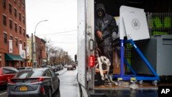 FILE - Workers load election materials into a truck in the Brooklyn borough of New York, March 17, 2020. The state will hold its congressional and state-level primaries on June 23, but has canceled its Democratic presidential primary. 