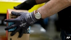 FILE - An employee packages a product at the Amazon Fulfillment center in Robbinsville Township, N.J., Aug. 1, 2017.